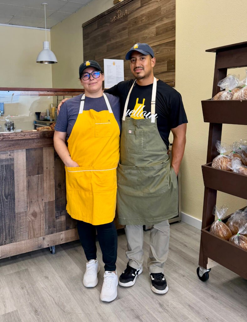 Owners of Yellow Apron Baking Co, Marilyn Ramirez Segundo and Luis Segundo behind the counter at their new location in Pearland Texas